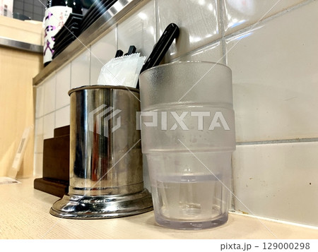 定食屋のカウンター席　カウンター席に置かれたグラスとナプキン 129000298