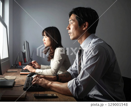 並んでパソコンを使うビジネスマン 並んでパソコンを使うビジネスマン 129001548