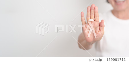 Elderly woman with Peach Ribbon for September Uterine Cancer Awareness month, Endometrial Cancer, Gynecologic, Uterus and Ovaries, Endometriosis, June Vaginal cancer and World cancer day concept 129001711