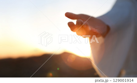 The hand of Jesus Christ reaching out with arms outstretched, the hand gesture of Jesus who died on the cross and was resurrected, heaven, salvation and Easter background 129001914