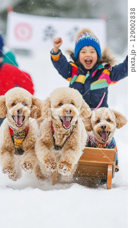 雪原でそりを引いて走る犬と大はしゃぎの子供 129002838