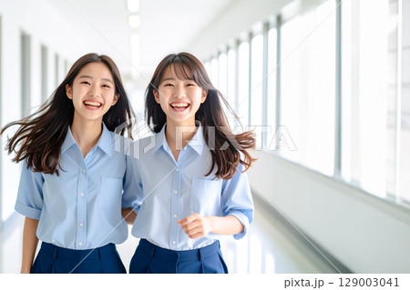 廊下ではしゃいでいるふたりの女子学生 廊下ではしゃいでいるふたりの女子学生 129003041