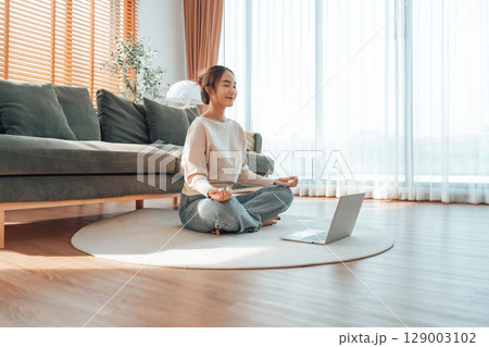 Happy young Asian woman practicing yoga and meditation at home Happy young Asian woman practicing yoga and meditation at home 129003102