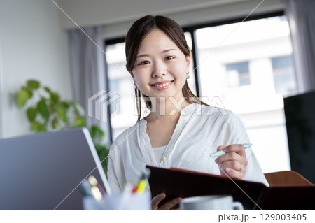 自宅でオンライン会議をする若い女性 自宅でオンライン会議をする若い女性 129003405