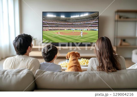 家族と犬がソファでくつろぎながら野球観戦するひととき 129004216