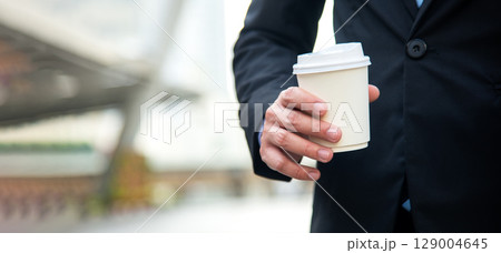Close up hand businessman with hot cup coffee for working in office city. Business Concept Close up hand businessman with hot cup coffee for working in office city. Business Concept 129004645