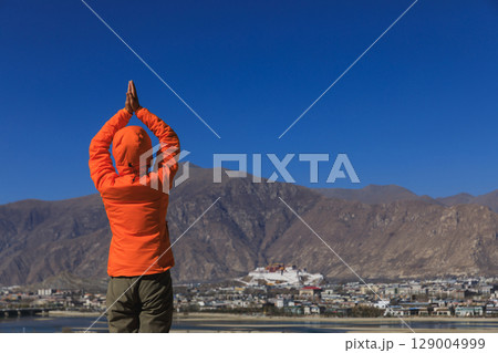 Woman praying to the potala palace in Lhasa city,Tibet,China 129004999