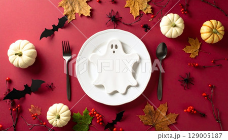 Red and white and red and green masks on a festive table setting with a holiday floral centerpiece Red and white and red and green masks on a festive table setting with a holiday floral centerpiece 129005187