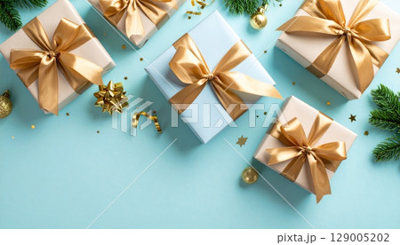 Golden Christmas gift box with a shiny red ribbon and bow, ready for a festive holiday celebration Golden Christmas gift box with a shiny red ribbon and bow, ready for a festive holiday celebration 129005202