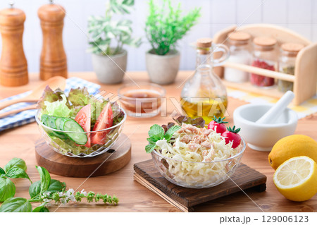 オリーブオイルをかけた彩り野菜サラダの食卓 129006123