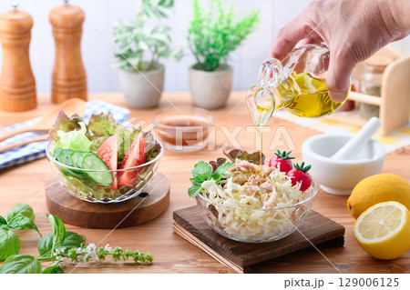 オリーブオイルをかけた彩り野菜サラダの食卓 129006125