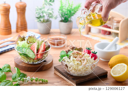 オリーブオイルをかけた彩り野菜サラダの食卓 129006127