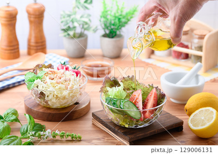 オリーブオイルをかけた彩り野菜サラダの食卓 129006131
