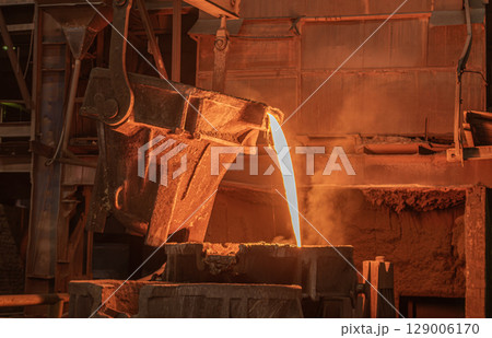Molten metal pours out of a ladle Molten metal pours out of a ladle 129006170