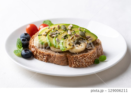 Avocado toast with banana, sunflower seed, pumpkin seed, sesame seed, blueberry and tomatoes Avocado toast with banana, sunflower seed, pumpkin seed, sesame seed, blueberry and tomatoes 129006211