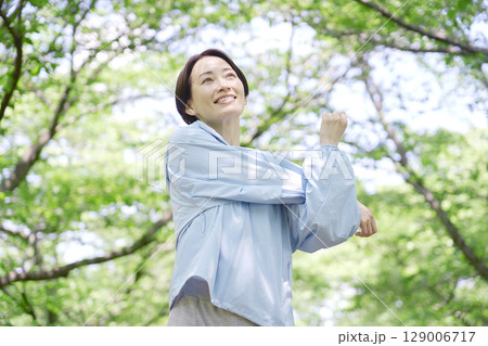 屋外で準備運動をする40代女性 129006717