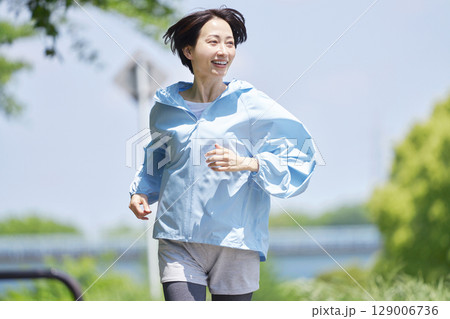 屋外でランニングする40代女性 屋外でランニングする40代女性 129006736