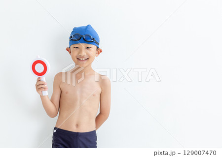 マルのプレートを持った水着を着た男の子 129007470