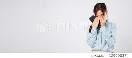 Vision problem Young Asian woman rubbing eyes from fatigue, vision blurred after using glasses, stress and pain showing eye discomfort with tired hands. isolated studio white background Vision problem Young Asian woman rubbing eyes from fatigue, vision blurred after using glasses, stress and pain showing eye discomfort with tired hands. isolated studio white background 129008374