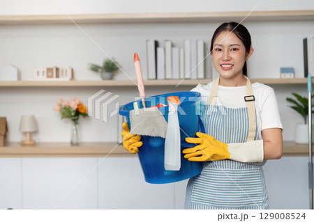 Home Cleaning. Smiling woman with cleaning bucket and supplies, ready to clean. Home Cleaning. Smiling woman with cleaning bucket and supplies, ready to clean. 129008524