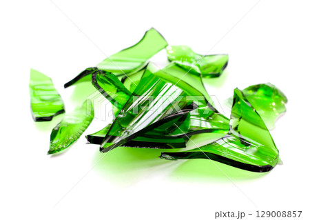 Sharp green glass shards scattered on a white background. 129008857