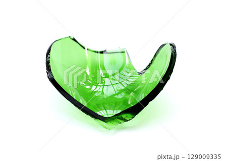 Sharp green glass shards scattered on a white background. Sharp green glass shards scattered on a white background. 129009335