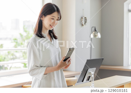 ホテルで受付をする若い女性 タブレット セルフチェックイン ホテルで受付をする若い女性 タブレット セルフチェックイン 129010181