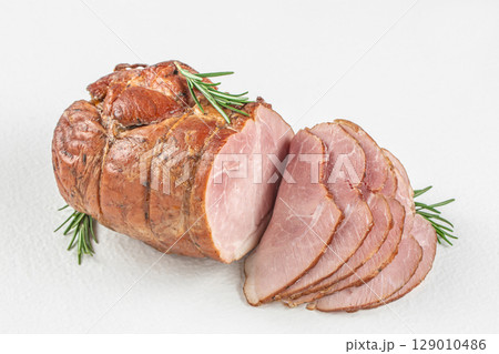 Smoked ham roast with rosemary sliced on a white background 129010486