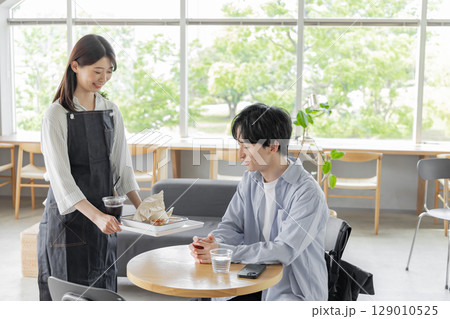 カフェで配膳するウェイトレス カフェで配膳するウェイトレス 129010525