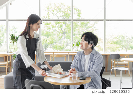 カフェで配膳するウェイトレス カフェで配膳するウェイトレス 129010526