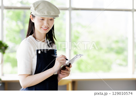 オーダを取るカフェ店員 129010574