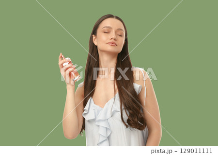 Woman applying perfume in a soothing setting 129011111