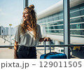Sunkissed Traveler Smiles with Anticipation by Airport Terminal Window. 129011505
