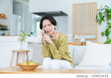 電話で悩むミドルの女性 129012419