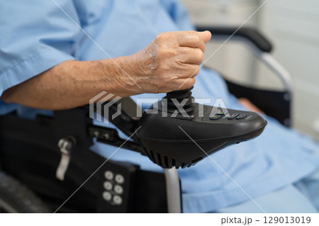 Asian senior woman patient on electric wheelchair with remote control at hospital, healthy strong medical. Asian senior woman patient on electric wheelchair with remote control at hospital, healthy strong medical. 129013019