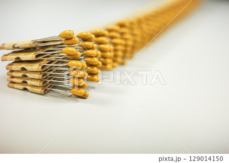 Yellow ceramic disc capacitors aligned in a diagonal row 129014150