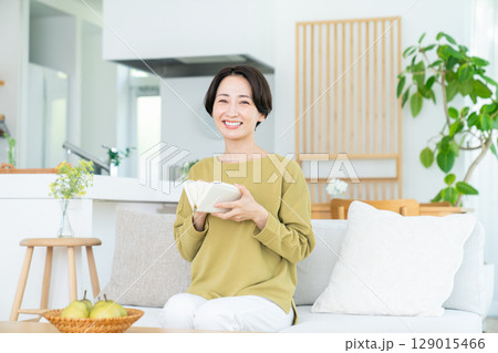 リビングで財布見るミドルの女性 リビングで財布見るミドルの女性 129015466