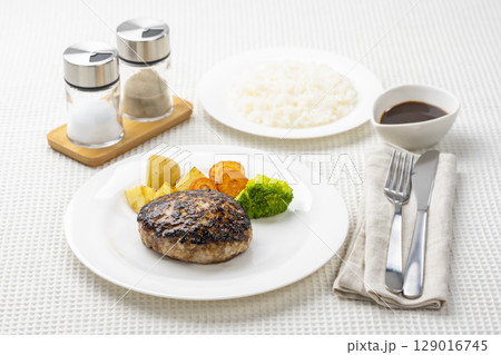白いテーブルにハンバーグとライスの洋食セット 129016745