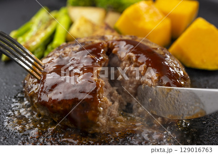 鉄板で焼いたハンバーグをナイフでカットする瞬間 129016763