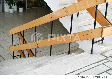 A flight of stairs with marble steps. Whitewashed walls and wooden staircase railings. The staircase of an old building. A flight of stairs with marble steps. Whitewashed walls and wooden staircase railings. The staircase of an old building. 129017119