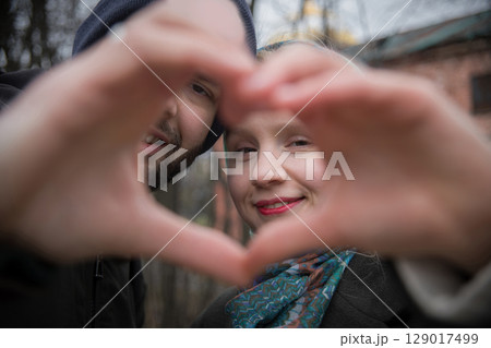 Young people being held together while showing the heart. Happy young man and woman 129017499