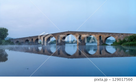 Ancient Bridge Over Misty River, Mystical Journey, Historic Crossroads, Timeless Passage. Perfect for historical travel, fantasy themes, philosophical concepts Ancient Bridge Over Misty River, Mystical Journey, Historic Crossroads, Timeless Passage. Perfect for historical travel, fantasy themes, philosophical concepts 129017560