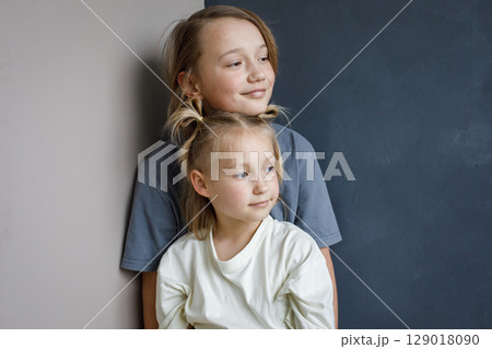 Smiling young sister and brother hugging indoor. Sibling children together portrait Smiling young sister and brother hugging indoor. Sibling children together portrait 129018090