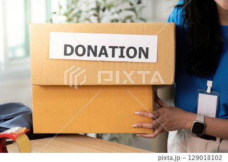 Volunteer carrying donation box, promoting community support 129018102