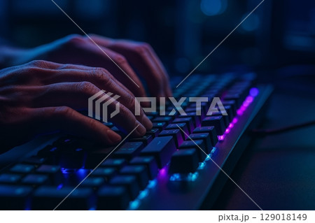 Close-up of hands typing on a gaming keyboard with RGB backlighting Close-up of hands typing on a gaming keyboard with RGB backlighting 129018149