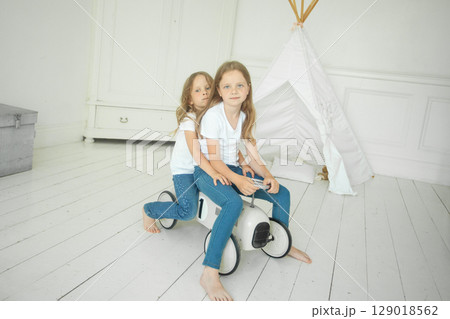 Beautiful little children sisters playing toy car together at home 129018562