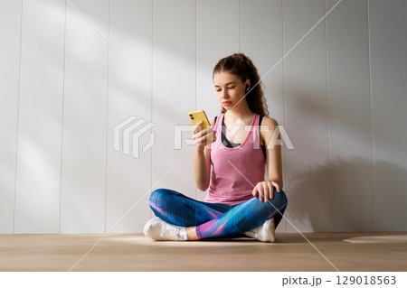 Woman in fashionable sportswear is doing exercise. 129018563