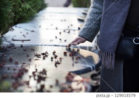 Touching a Cold Marble Surface Scattered With Leaves During a Serene Afternoon in a Garden 129018579