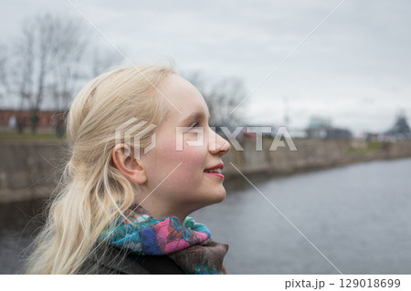 Nice young woman with blond hair walking outdoors, portrait Nice young woman with blond hair walking outdoors, portrait 129018699