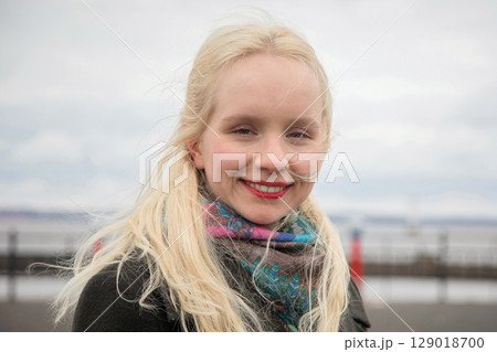 Portrait of happy young woman enjoying windy day Portrait of happy young woman enjoying windy day 129018700
